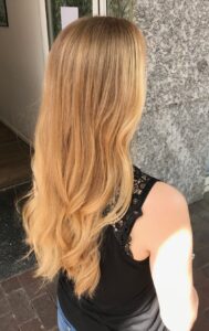 Erdbeerblond Balayage Look für langes, welliges Haar im Sommer 2023. Friseur HappyHairHarburg in Hamburg #blonde haarfarben #die schönsten blondtöne