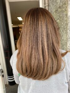 Haselnuss-braune Balayage-Haarfarbe für glatte, mittellange Haare, gestylt vom Friseur HappyHairHarburg in Hamburg.