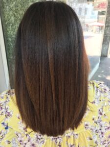 Caramel-braune Balayage-Haarfarbe für glatte, mittellange Haare, gestylt vom Friseur HappyHairHarburg in Hamburg.