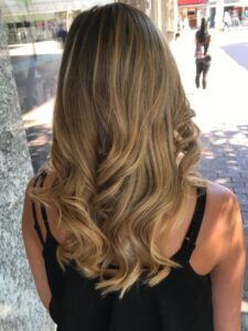 Natürlich goldblonde Strähnchen für welliges, langes Haar mit Redken-Produkten beim Friseur in Hamburg. #natürlichgoldblond #strähnchen #langeswelligeshaar