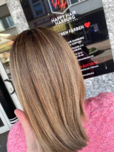 Goldblonde Strähnchen für glattes, langes Haar mit Redken-Produkten beim Friseur in Hamburg. #goldblondesträhnchen #glatteslangeshaar #redken