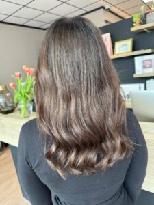 Kaffeebraune Foliage-Strähnchen auf welligem, langem Haar mit L'Oréal-Produkten.