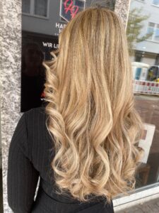 Caramel-goldblondes Balayage für welliges, langes Haar mit Redken-Produkten beim Friseur in Hamburg. #caramelgoldblond #balayage #langeswelligeshaar