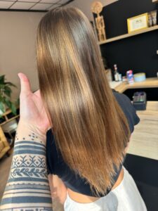 Gold-braune Balayage auf glattem, langem Haar mit Schwarzkopf-Produkten.