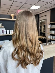 Zimtbraune Foliage-Strähnchen auf welligem, langem Haar mit Schwarzkopf-Produkten.