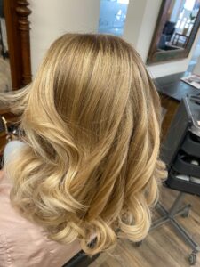 Natürlich goldblonde Strähnchen für welliges, langes Haar mit Wella-Produkten am Hamburger Fischmarkt. #natürlichgoldblond #strähnchen #langeswelligeshaar