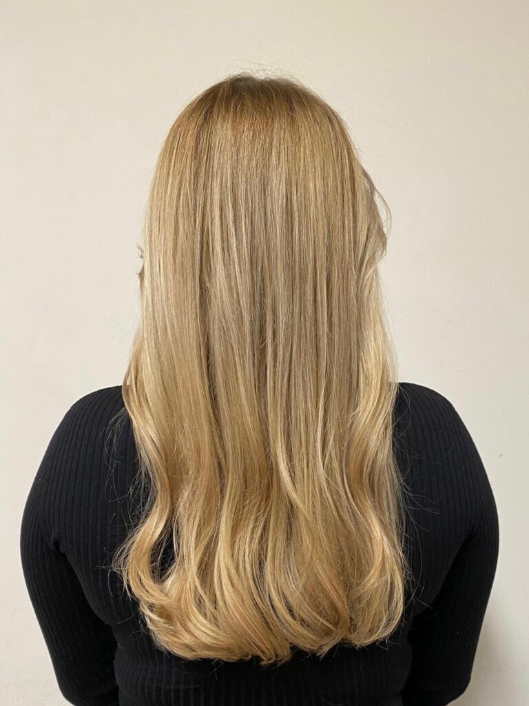 Helles goldblondes, welliges Haar mit Foliage-Technik und Wella-Produkten für einen Besuch an den Landungsbrücken in Hamburg im Frühling 2024. #goldblondeshaar #welligeslanghaar #foliagetechnik #friseurhamburg
