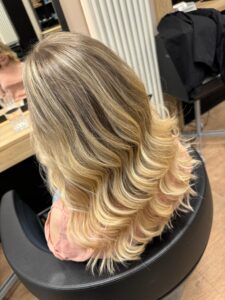 Goldblondes, lockiges Langhaar mit Foliage-Technik und Wella-Produkten für einen Besuch in der Speicherstadt Hamburg im Frühling 2024. #goldblondeshaar #lockigeslanghaar #foliagetechnik #speicherstadthamburg