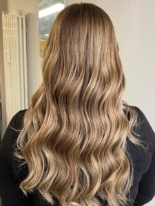 Goldblondes Twilighting, welliges Langhaar mit Balayage-Technik und Wella-Produkten für einen Besuch auf der Reeperbahn in Hamburg im Frühling 2024. #goldblondestwilighting #welligeslanghaar #balayagetechnik #reeperbahnhamburg